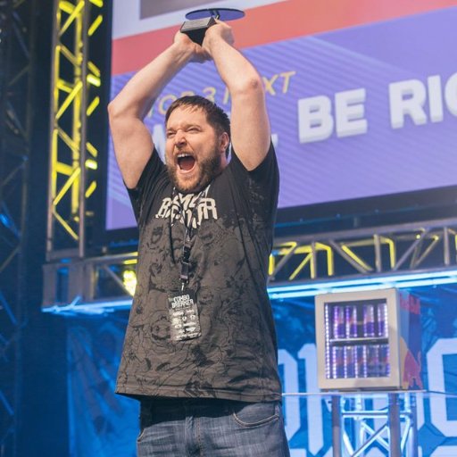 john "zansam" amenta, holding a staff award onstage at combo breaker